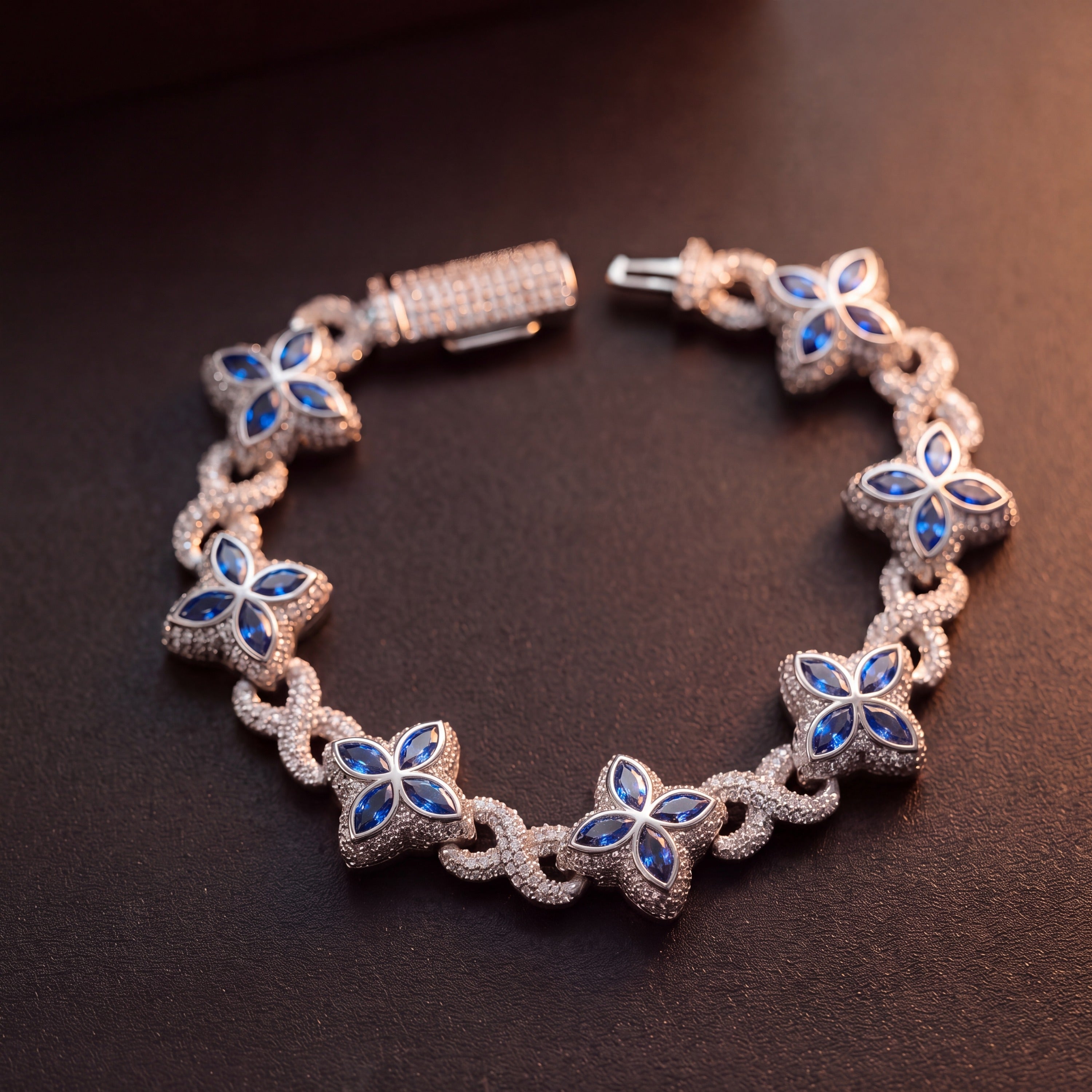 Silver-tone clover flower bracelet laid flat, blue marquise petals on pave links